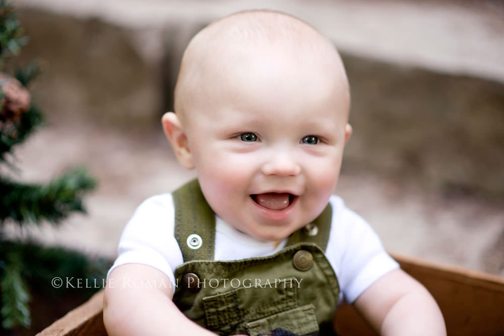 outdoor little man baby boy smiling with green overalls on outside