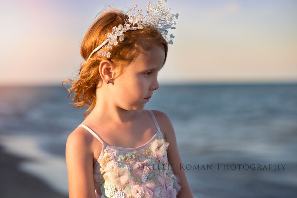 the great lakes girl with red hear wearing jewel crown standing on beach watching the water profile photo 
