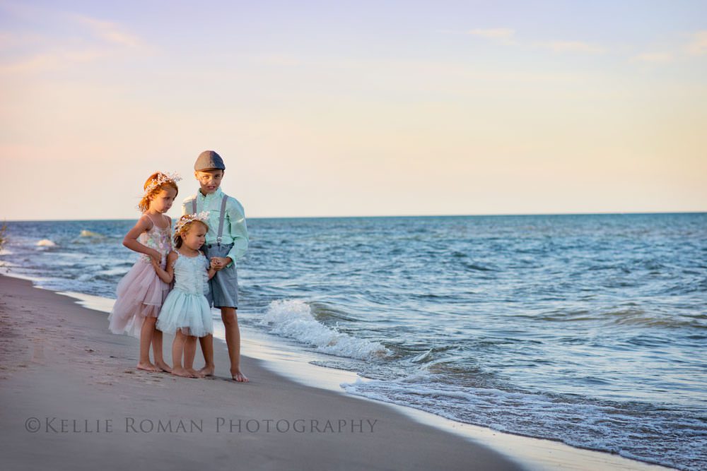 the great lakes three children standing on beach watching the waves roll in