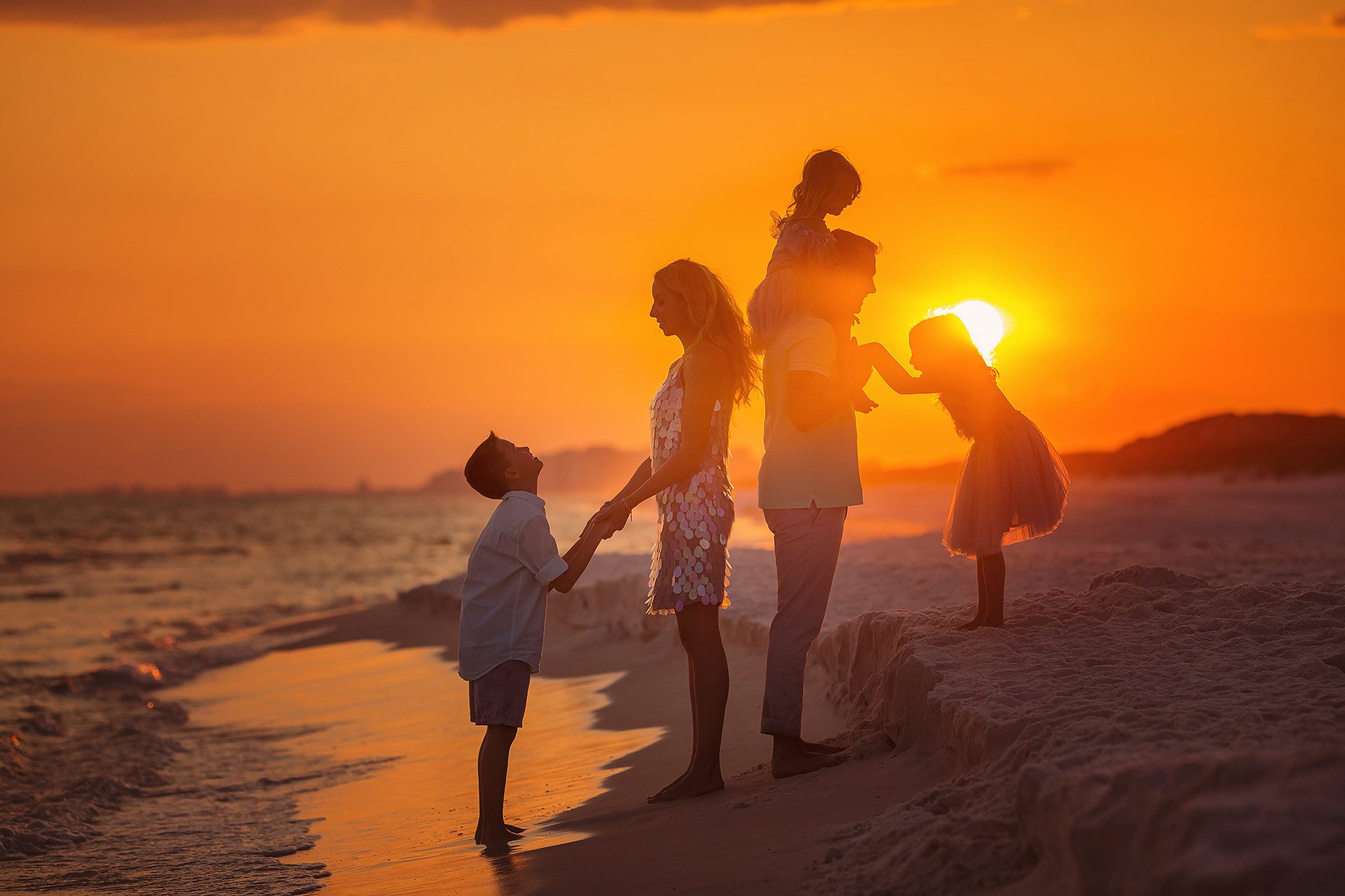 photography session with Kansas Pitts a family on he beach in Florida who are from milwaukee Wisconsin it's a silhouette image with the golden sunset coming from behind the family
