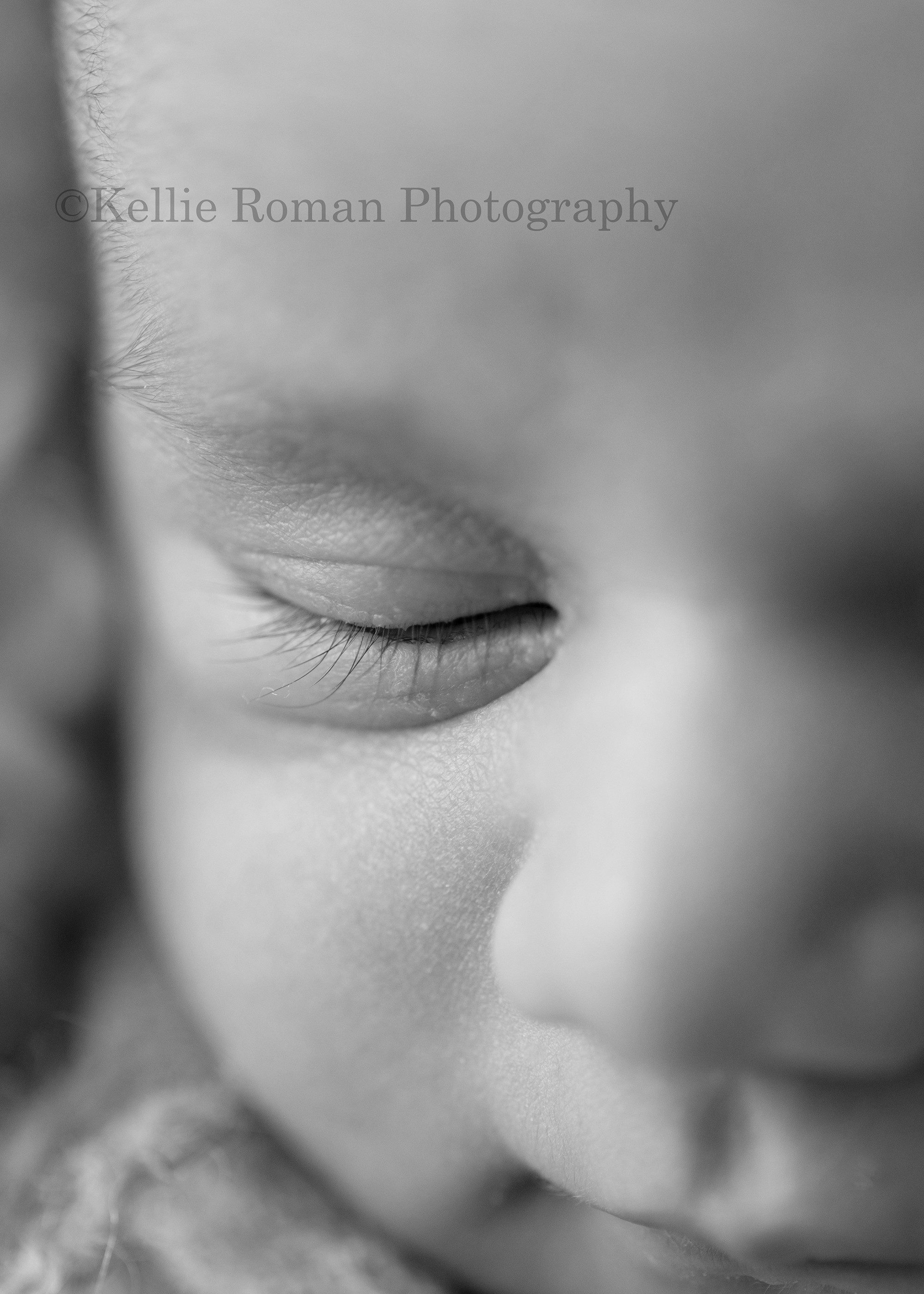 milwaukee newborn photographer. A close up shot of a baby girl in a Milwaukee photo studio located in greendale. The image is black and white and is a close up of the babies eye and lashes.