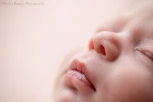 little newborn changes. a close up image of a baby girl in milwaukee photo studio. the close up is of the side of her nose and lips.